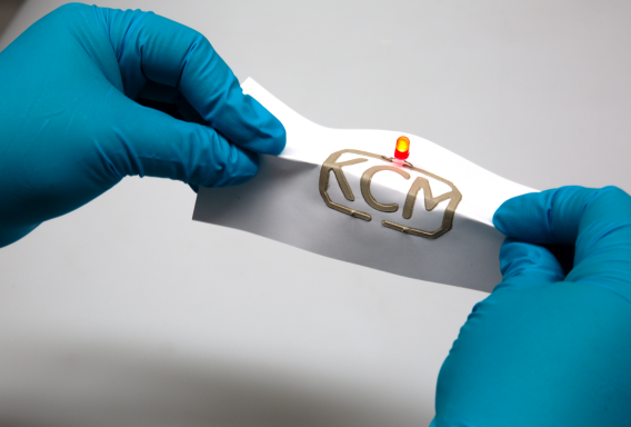 A bent sheet of paper with a printed flexible conductor.